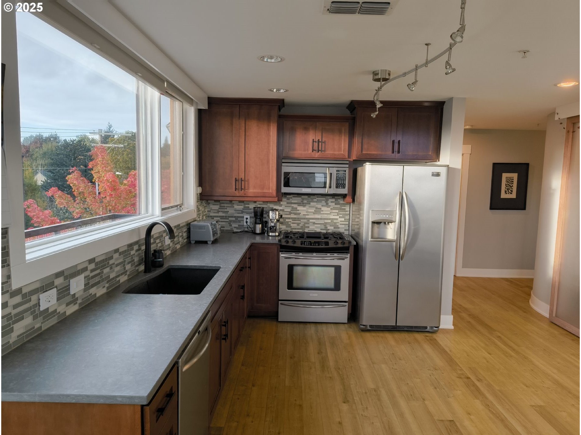 838 Southeast 38th Avenue, Unit 307 Portland, OR 97214 - Photo 5 of 16 a kitchen with stainless steel appliances a refrigerator sink and stove