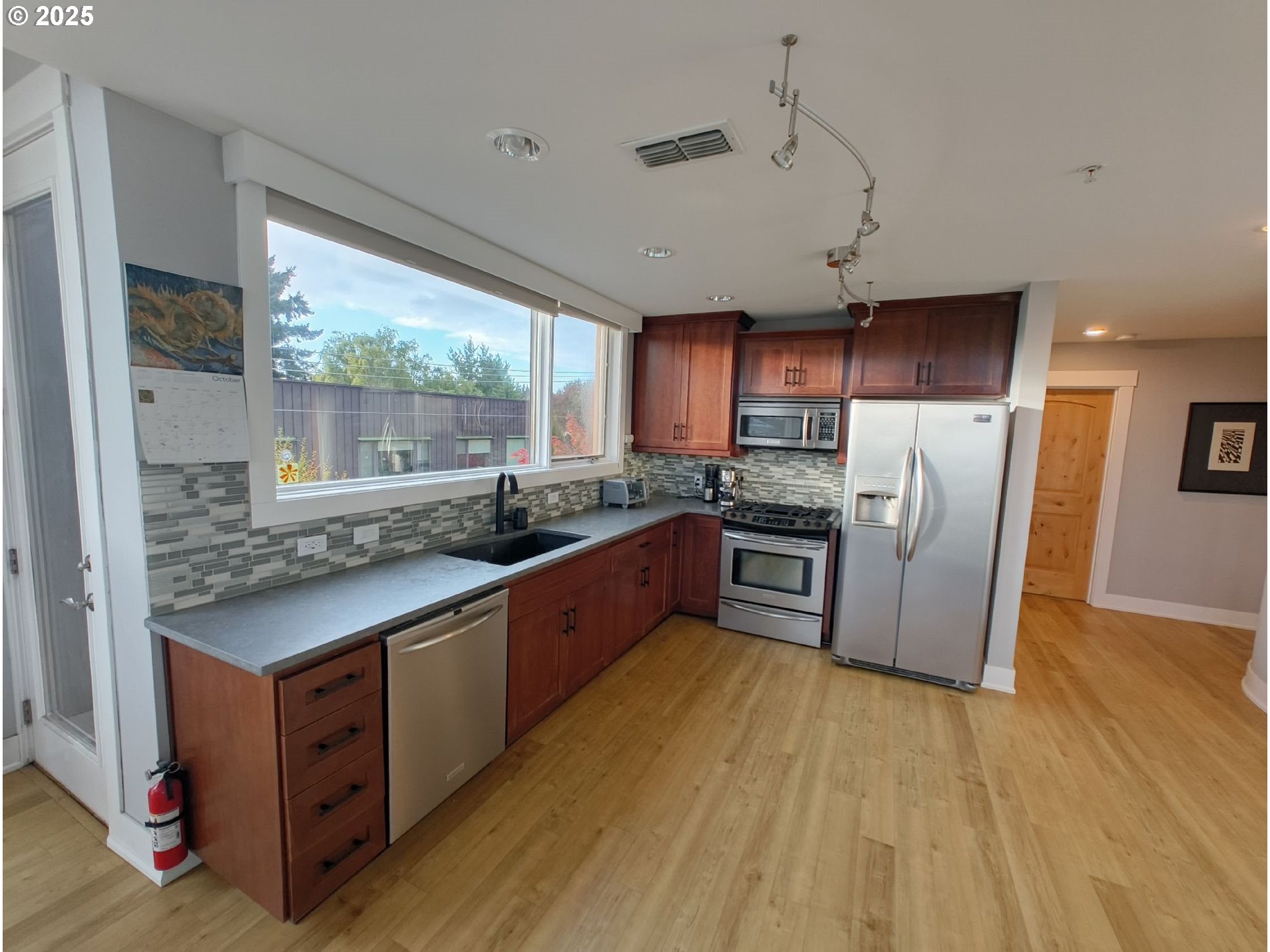 838 Southeast 38th Avenue, Unit 307 Portland, OR 97214 - Photo 6 of 16 a kitchen with stainless steel appliances granite countertop a stove a sink dishwasher a refrigerator and a oven with wooden floor