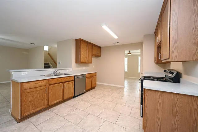 a large kitchen with stainless steel appliances granite countertop a sink and cabinets