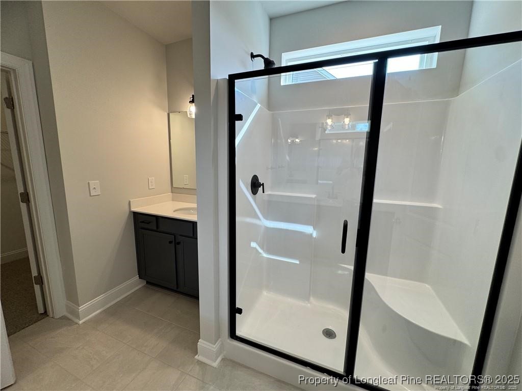 179 Grove Walk Road Raeford, NC 28376 - Photo 12 of 26 a bathroom with a glass shower door and a sink