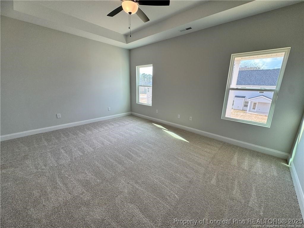 179 Grove Walk Road Raeford, NC 28376 - Photo 14 of 26 en empty room with windows and ceiling fan