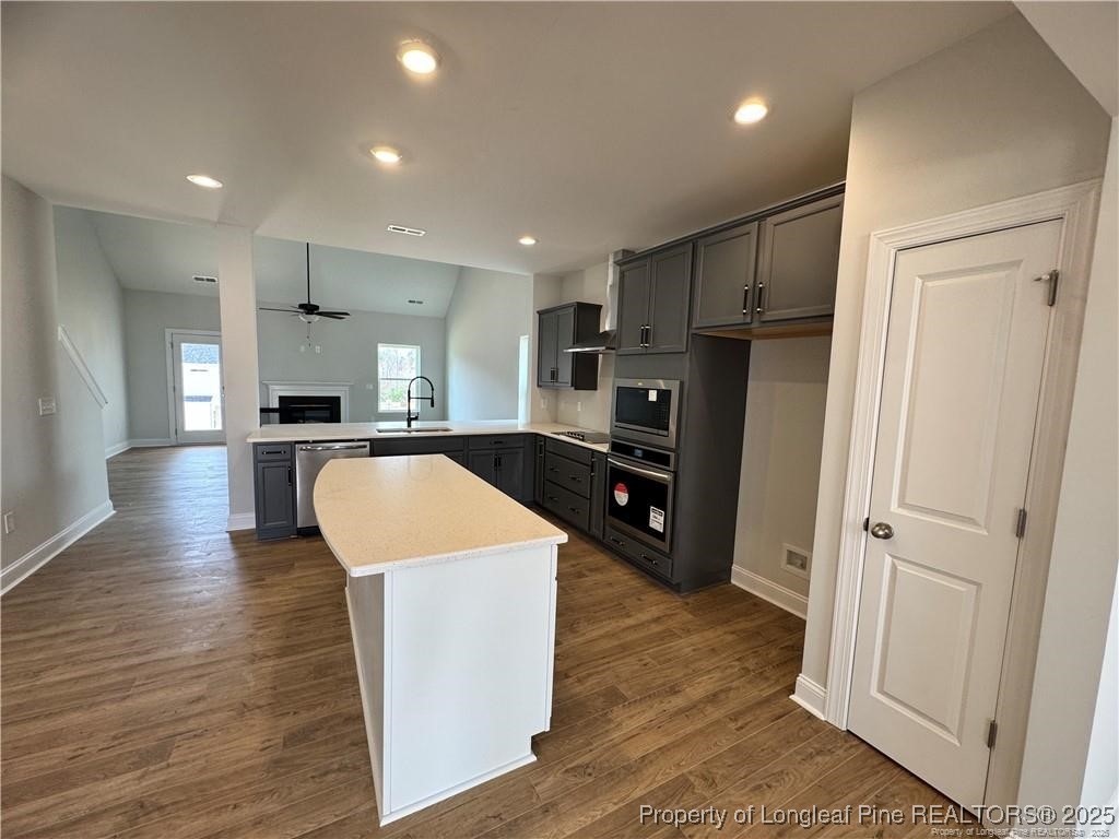 179 Grove Walk Road Raeford, NC 28376 - Photo 10 of 26 a large kitchen with a center island wooden floor and stainless steel appliances