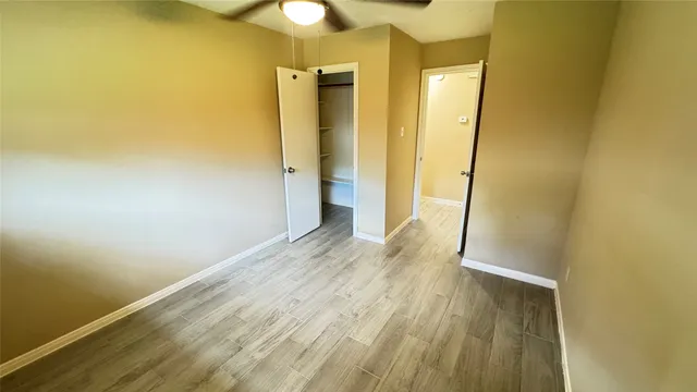 a view of a room with wooden floor and a bathroom