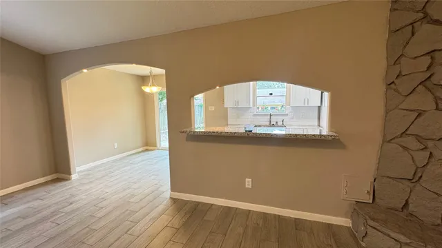 an empty room with wooden floor and mirror