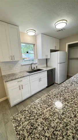 a kitchen with a sink a stove cabinets and a refrigerator