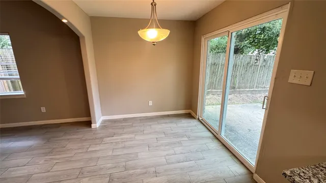 a view of a room with wooden floor and windows