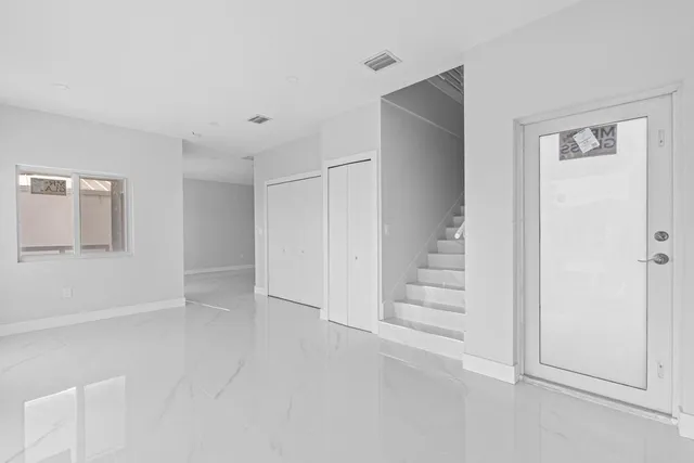 a view of an empty room with stairs and ventilation