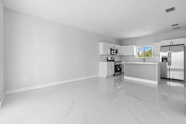 a view of wooden floor and windows in a kitchen