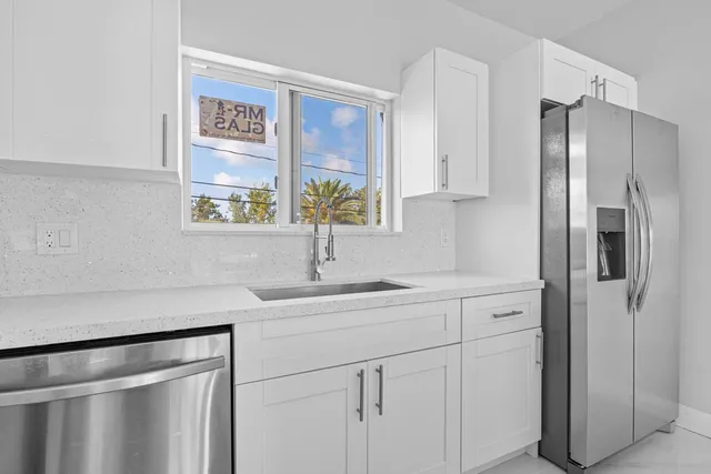 a kitchen with stainless steel appliances white cabinets and a window