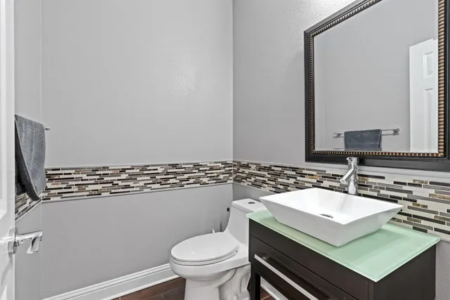 a bathroom with a sink mirror vanity and toilet