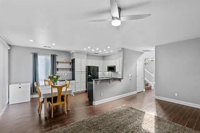 a view of a dining room and livingroom with furniture wooden floor a chandelier