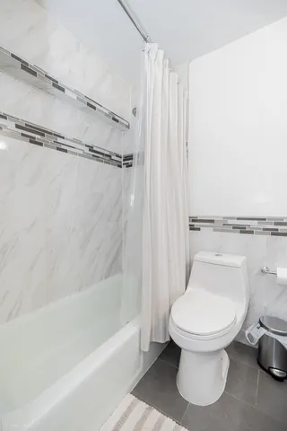 a bed sitting in a spacious bedroom next to a window