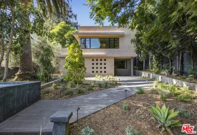 a front view of a house with a garden