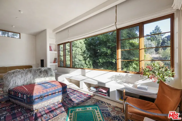 a bed sitting in a bedroom next to a window