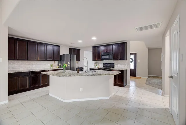 a kitchen with a sink a counter top space stainless steel appliances and cabinets