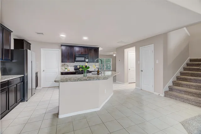 a kitchen with stainless steel appliances granite countertop a refrigerator and a sink