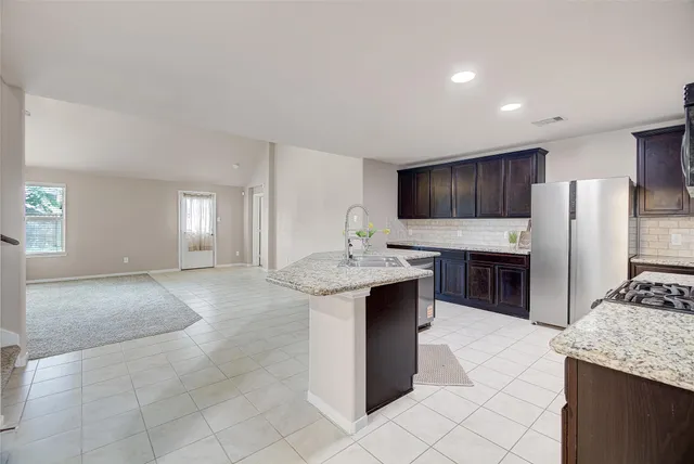 a kitchen with stainless steel appliances granite countertop a sink stove and refrigerator