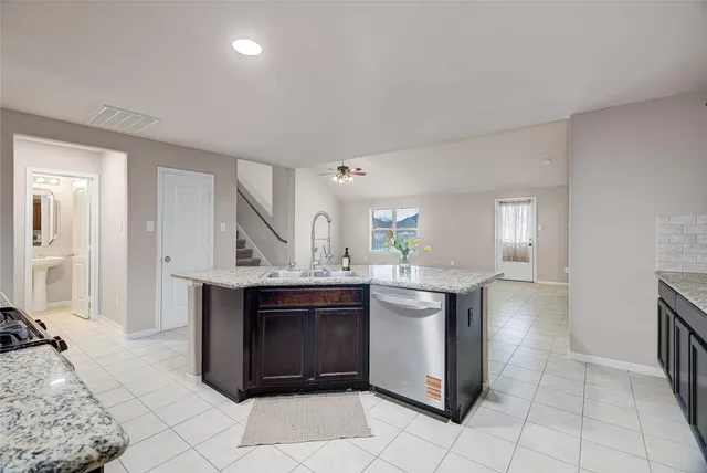 a kitchen with stainless steel appliances granite countertop a stove a sink and a refrigerator