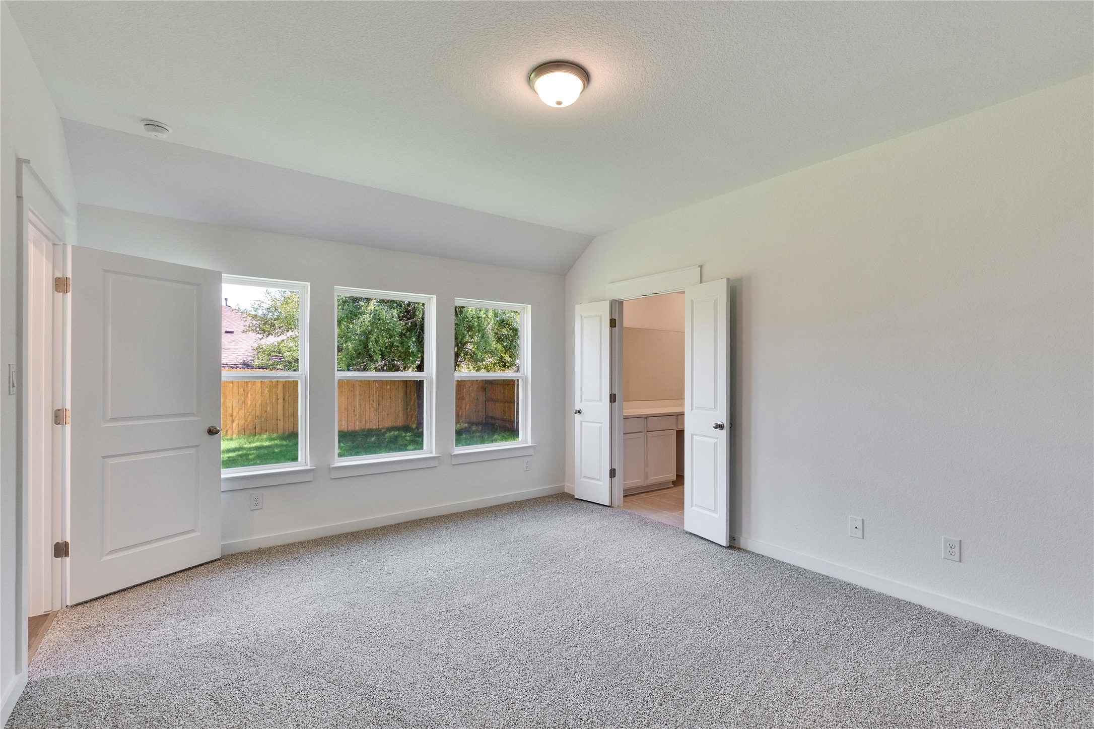 13509 Barn Chime Street Elgin, TX 78621 - Photo 39 of 40 Carpeted room with a vaulted ceiling and three large windows