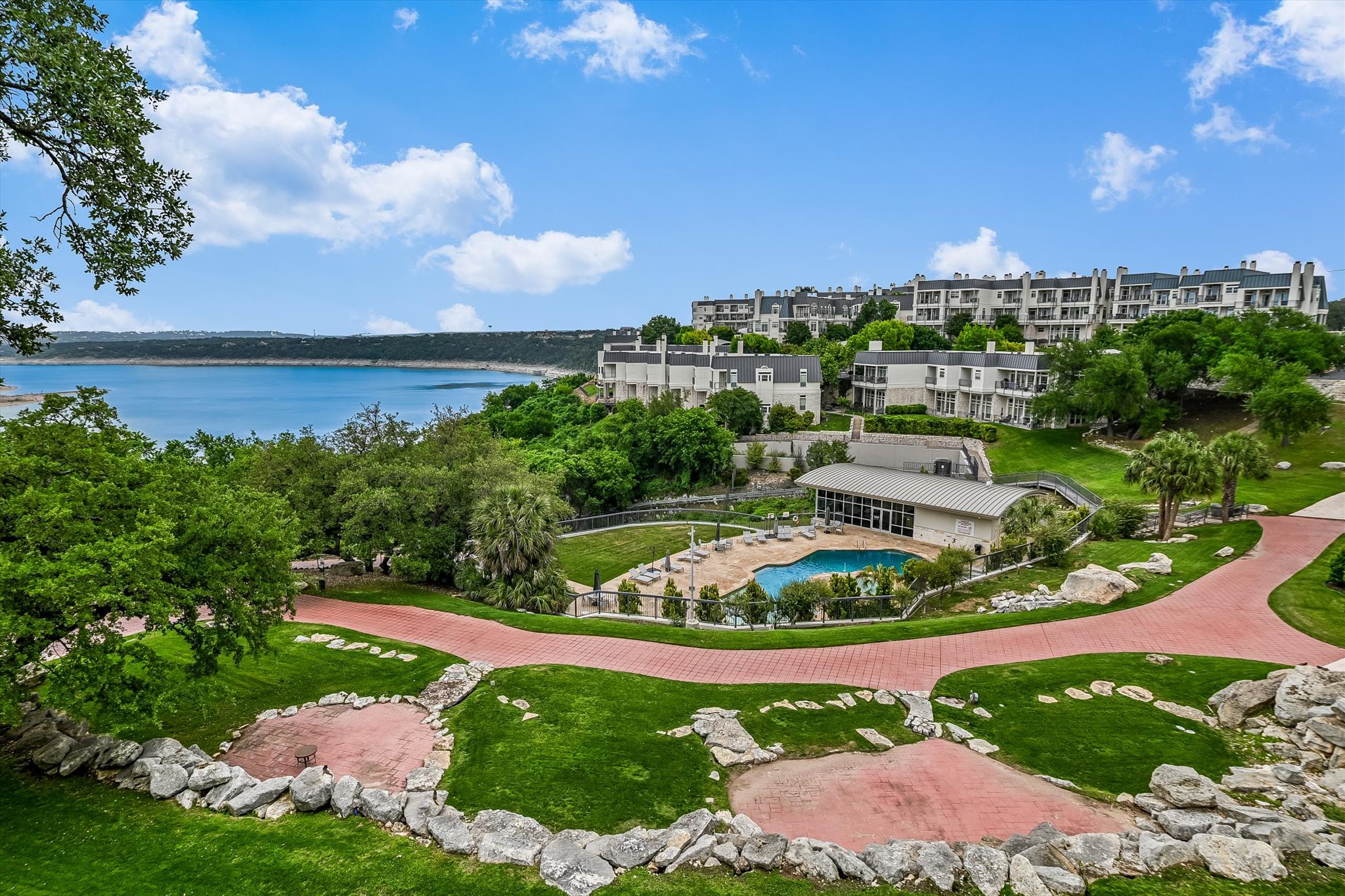 View from lower balcony of property's community featuring fence and a water view