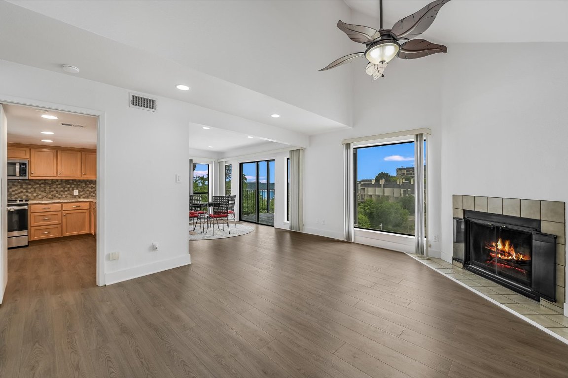 2918 Ranch Road 620 North, Unit B112 Austin, TX 78734 - Photo 3 of 10 Unfurnished living room featuring a tiled fireplace, baseboards, wood finished floors, recessed lighting, and ceiling fan