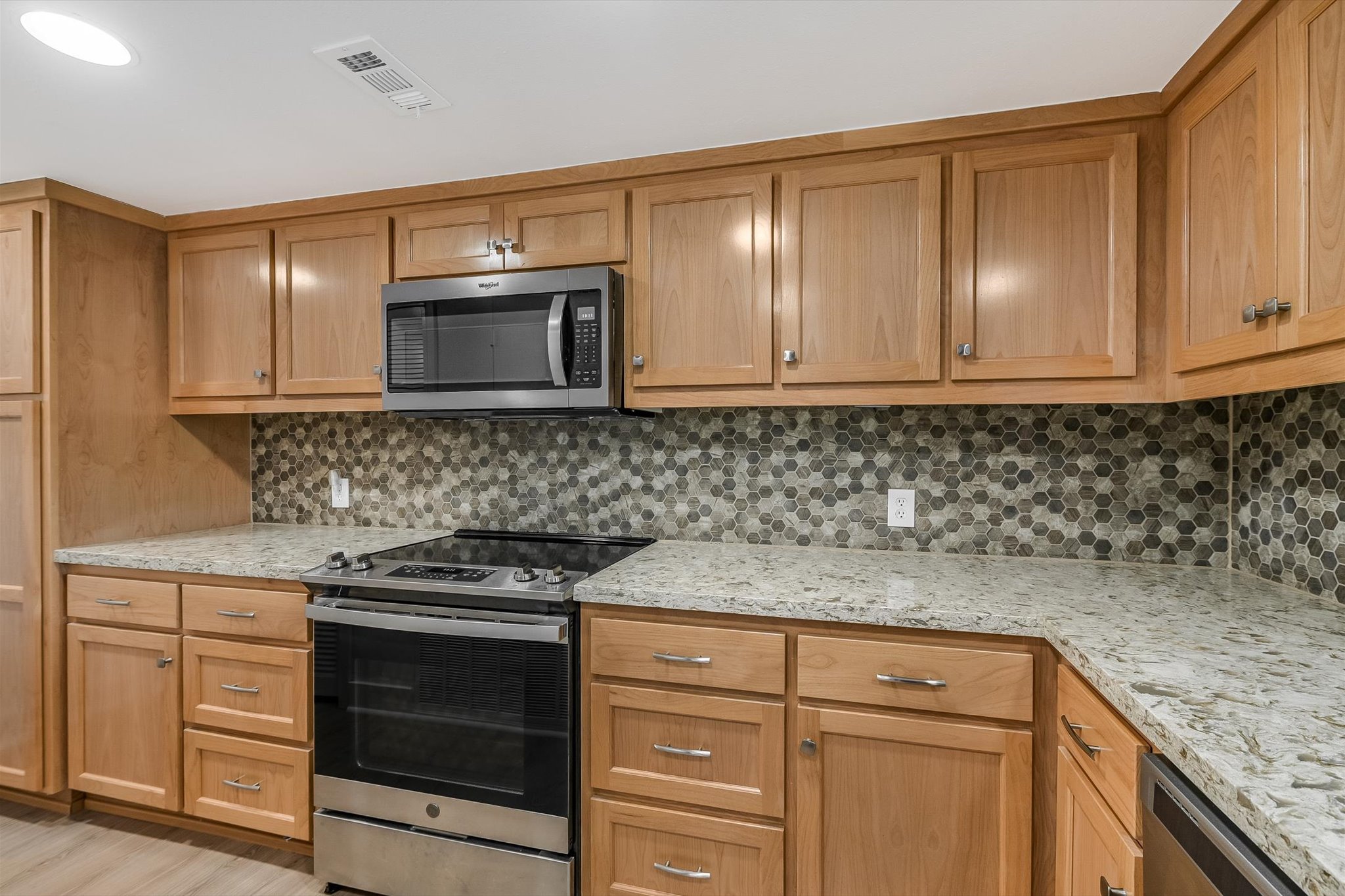 2918 Ranch Road 620 North, Unit B112 Austin, TX 78734 - Photo 5 of 10 Kitchen featuring stainless steel appliances, backsplash, light stone countertops, and light wood finished floors