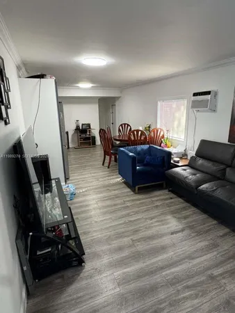 a living room with furniture and a gym machine