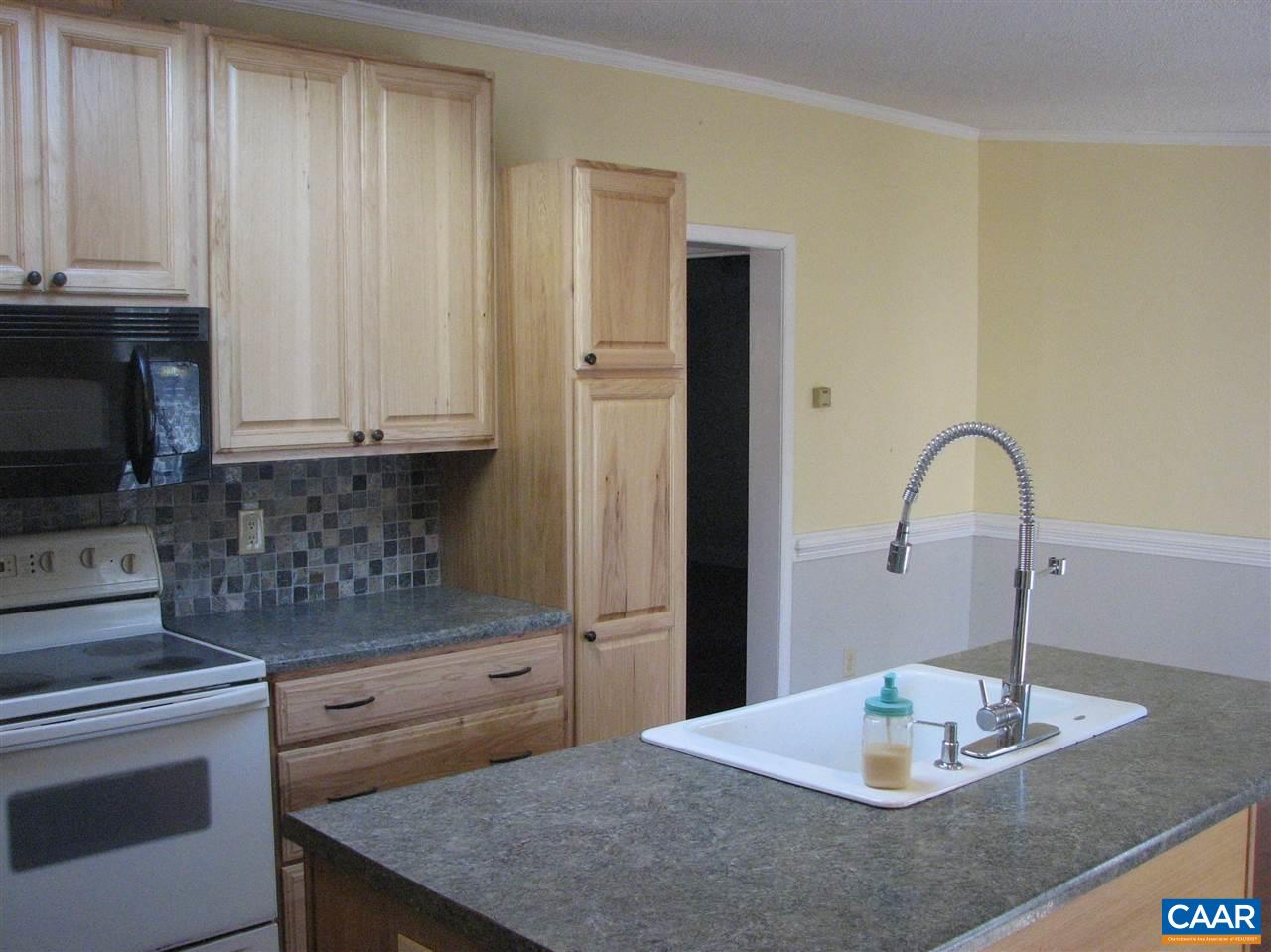 4247 Rising Sun Road Palmyra, VA 22963 - Photo 4 of 31 a kitchen with kitchen island granite countertop a stove a sink and a microwave