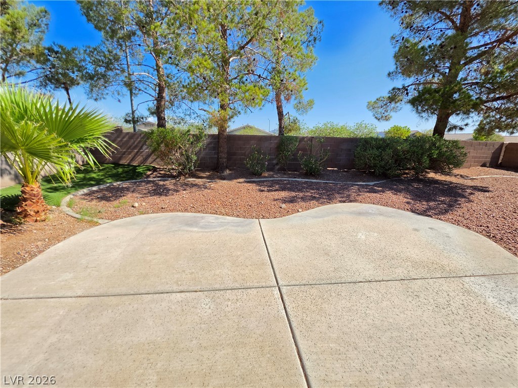 1154 Point Success Avenue Henderson, NV 89014 - Photo 23 of 26 A private yard with mature trees and a spacious patio for outdoor enjoyment.