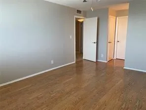 an empty room with wooden floor and closet