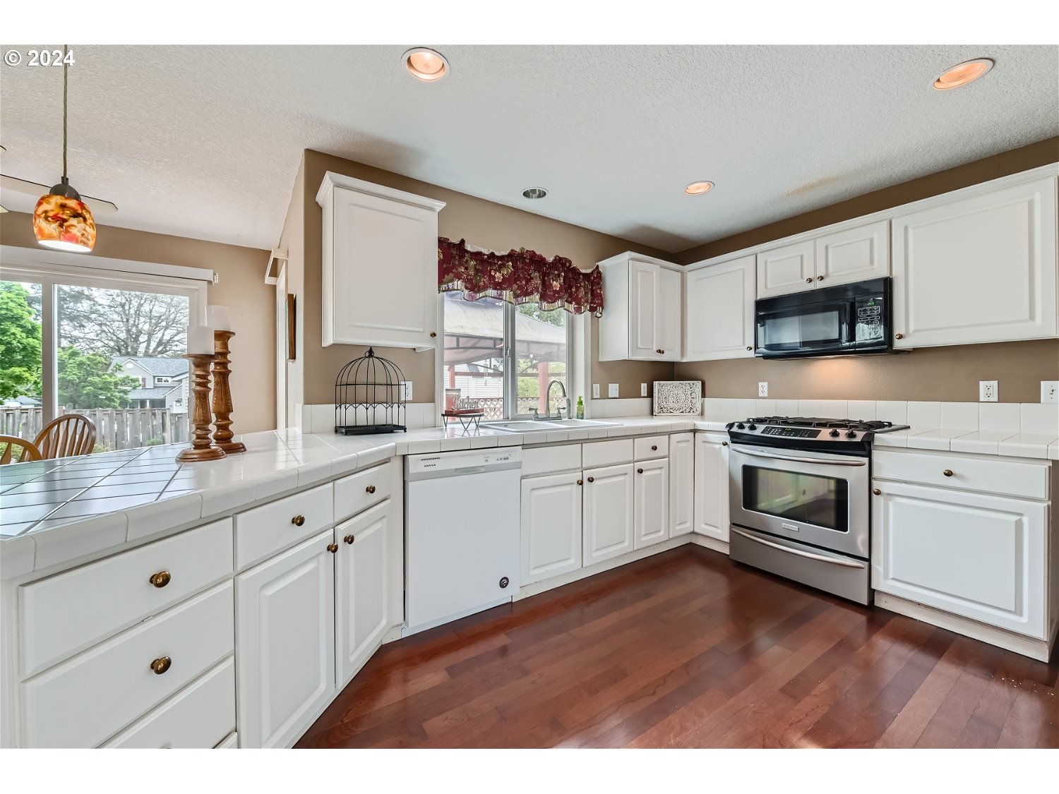 58916 Evergreen Loop St. Helens, OR 97051 - Photo 9 of 28 a kitchen with granite countertop white cabinets and white appliances