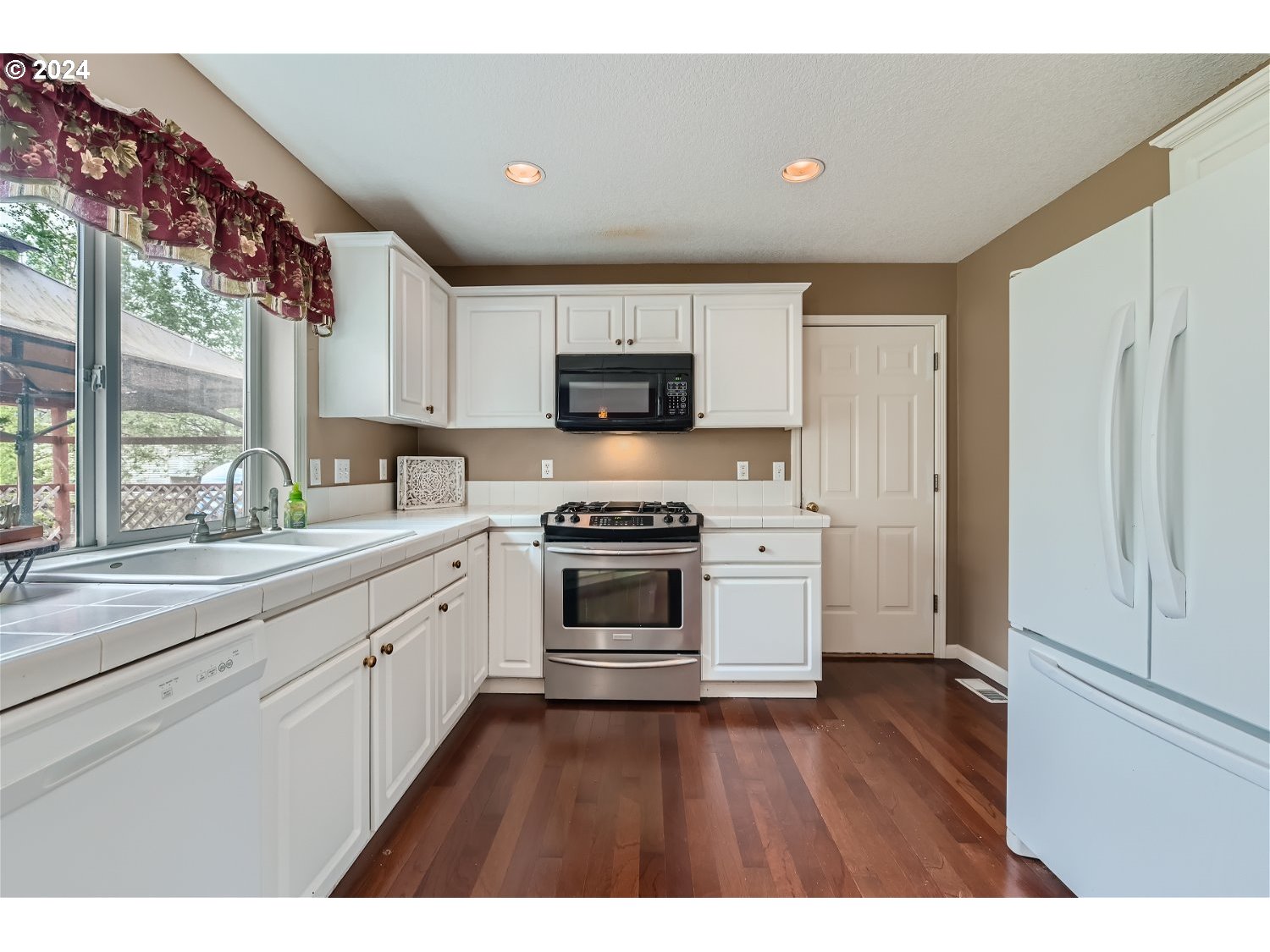 58916 Evergreen Loop St. Helens, OR 97051 - Photo 10 of 28 a kitchen with stainless steel appliances a stove top oven a sink and a refrigerator