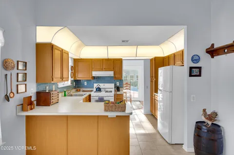 a kitchen with a refrigerator a stove and a dining table with wooden floor