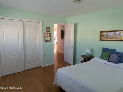 a bedroom with a bed and wooden floor