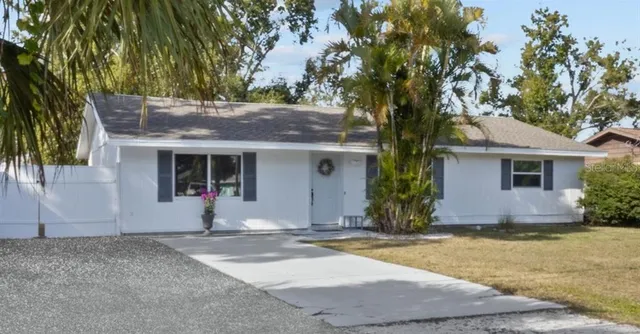 a front view of house with yard and trees around