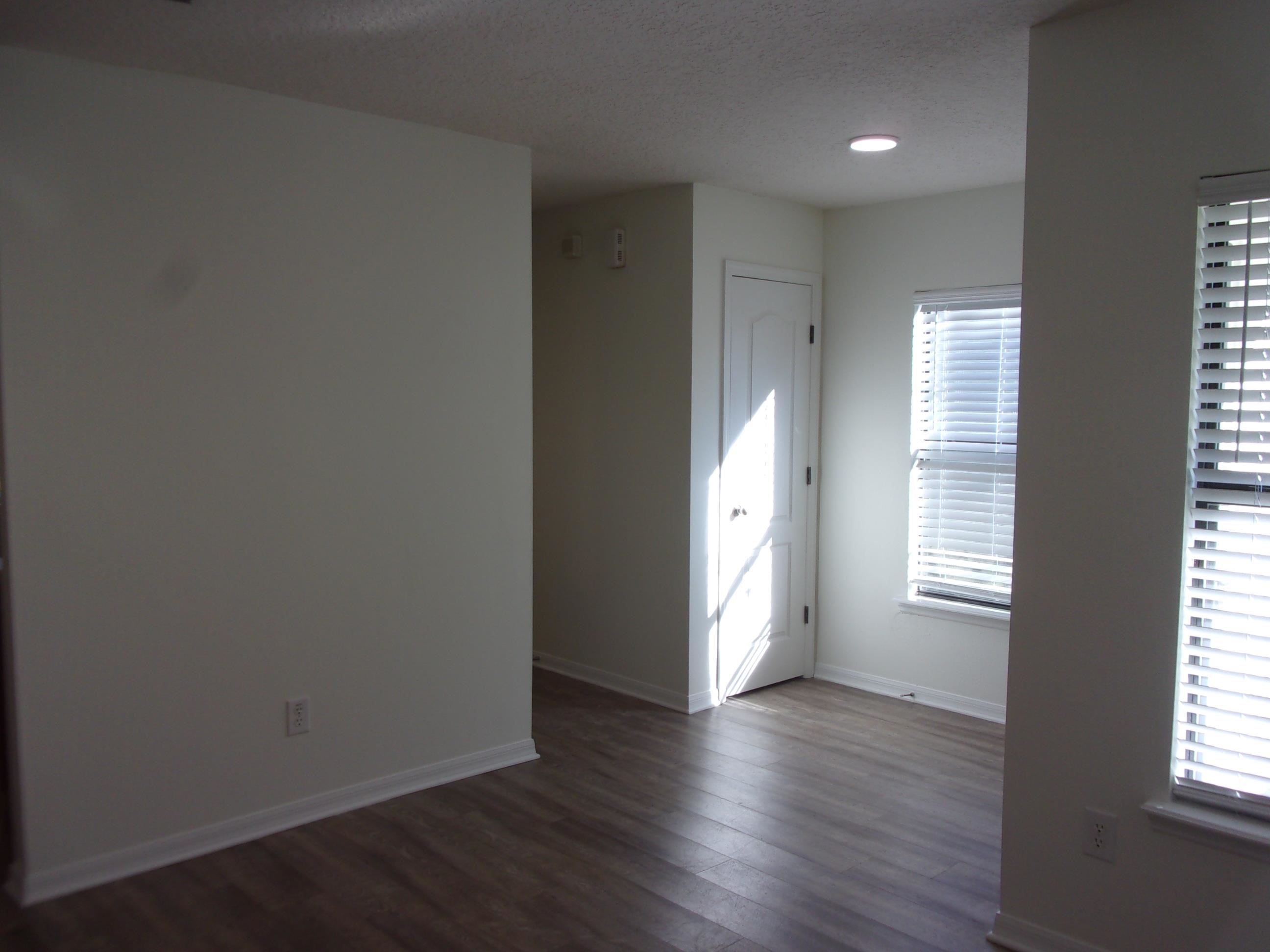 Empty room with dark wood-style flooring, a textured ceiling, and recessed lighting