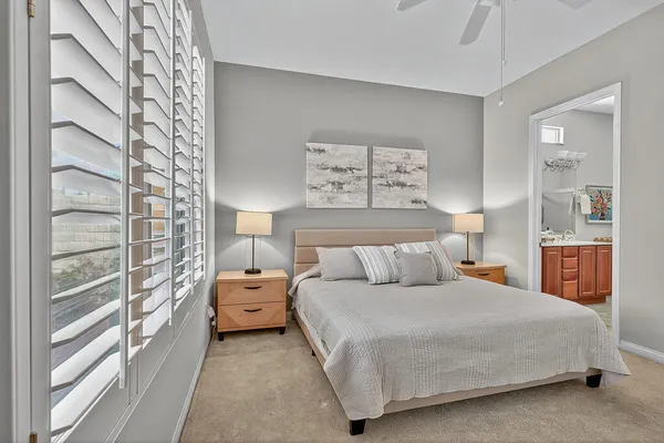 a bedroom with a bed and a lamp on dresser