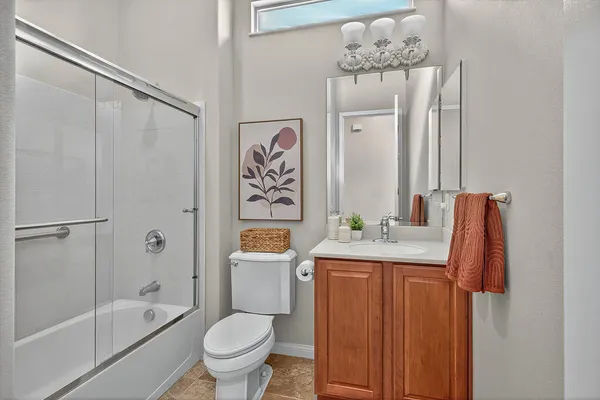 a bathroom with a granite countertop sink a toilet and shower