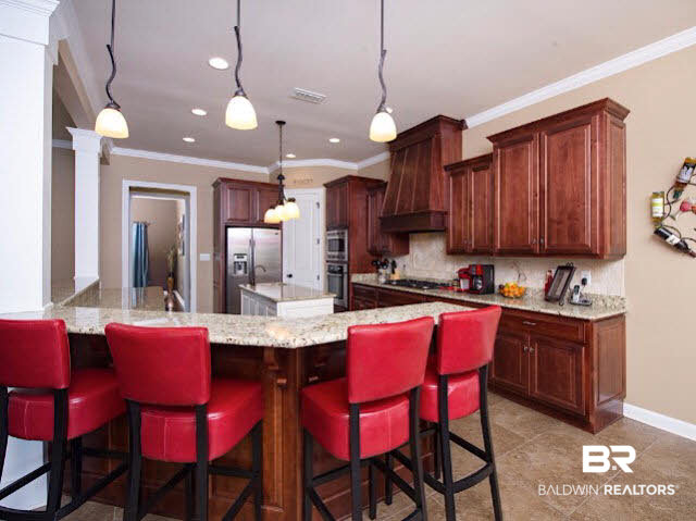 7814 Balin Drive Daphne, AL 36527 - Photo 8 of 26 Custom Kitchen with plenty of lighting and storage space, breakfast nook, breakfast bar, granite counter tops, multiple sinks, and stainless appliances for all your chef dreams!