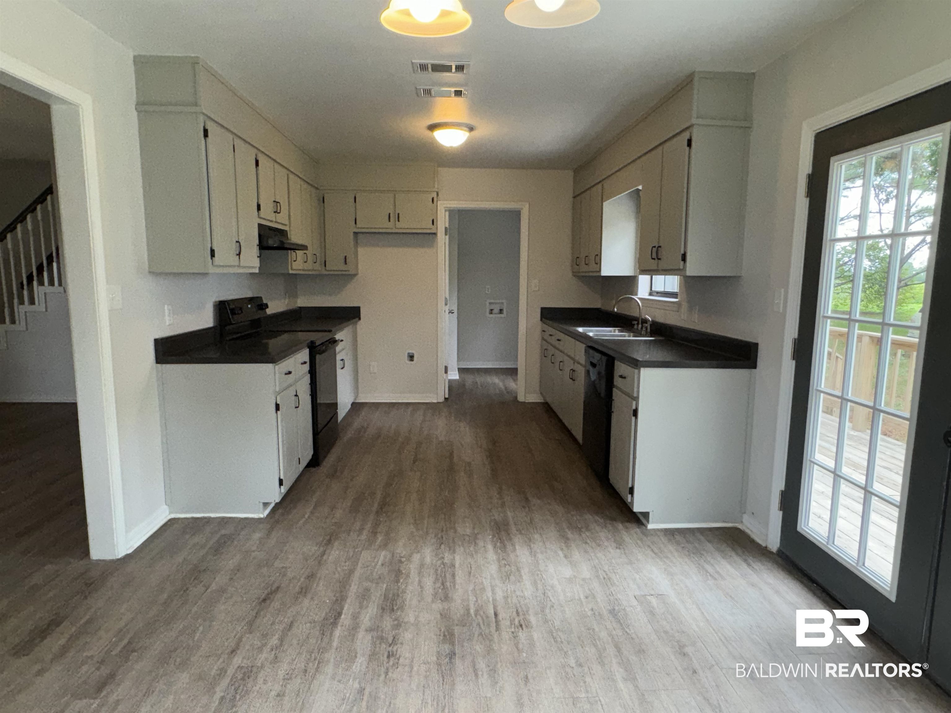 70 Plum Street Uriah, AL 36480 - Photo 6 of 36 Kitchen featuring black appliances, hardwood / wood-style floors, and sink