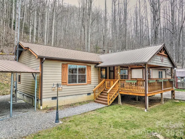 a view of a house with backyard and a tree