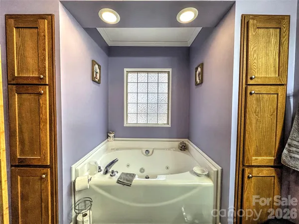 a bathroom with a granite countertop tub double vanity sink and a mirror