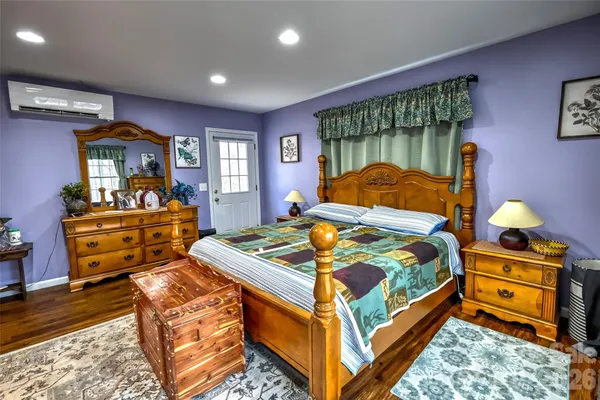 a room with stainless steel appliances granite countertop a refrigerator a sink dishwasher and a dining table with wooden floor