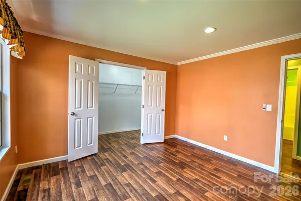 a view of room with wooden floor and furniture