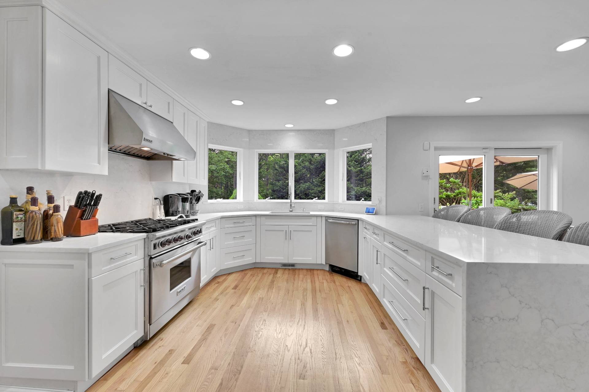105 Northside Drive Sag Harbor, NY 11963 - Photo 13 of 33 a large kitchen with stainless steel appliances a white stove top oven and white cabinets with wooden floor