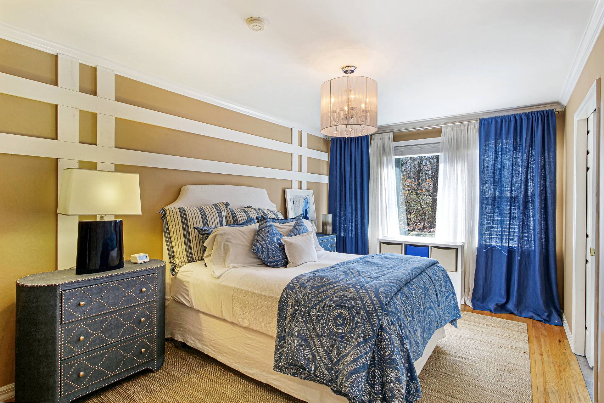 105 Northside Drive Sag Harbor, NY 11963 - Photo 23 of 33 a bedroom with a bed and a chandelier