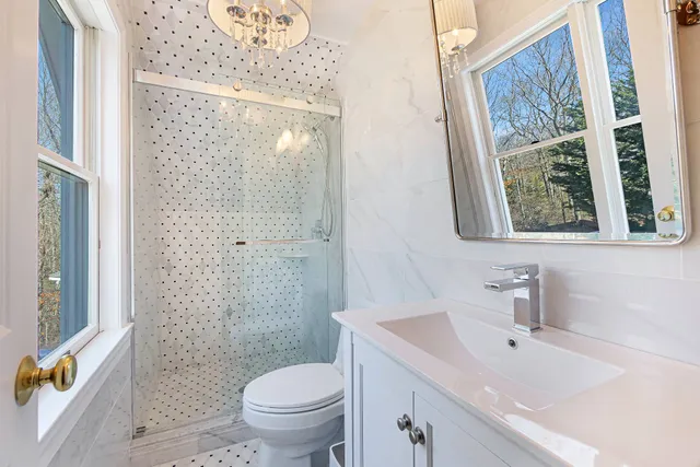 a bathroom with a sink a toilet and shower