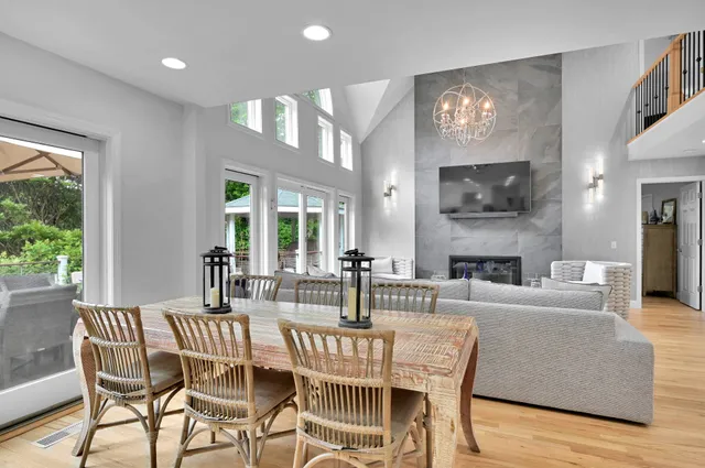 a view of a dining room with furniture a fireplace and wooden floor