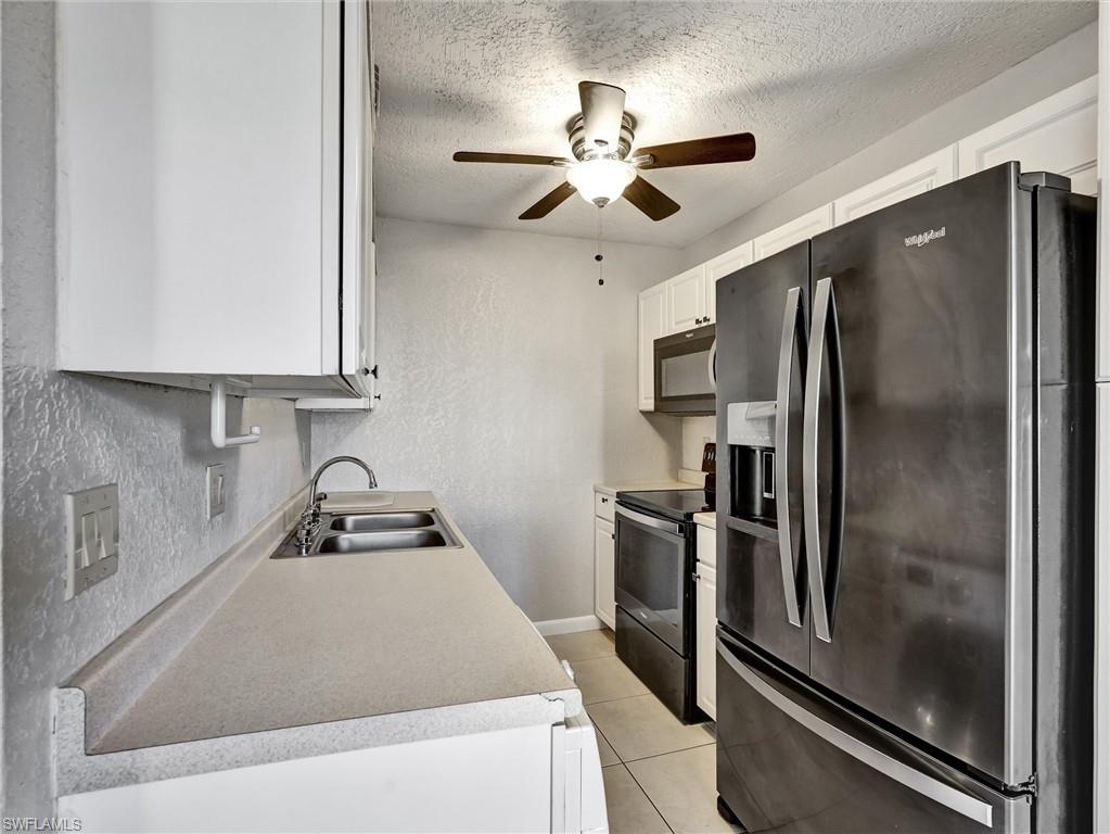 4621 Bayshore Drive, Unit Q1 Naples, FL 34112 - Photo 12 of 25 a kitchen with stainless steel appliances granite countertop a refrigerator and a sink