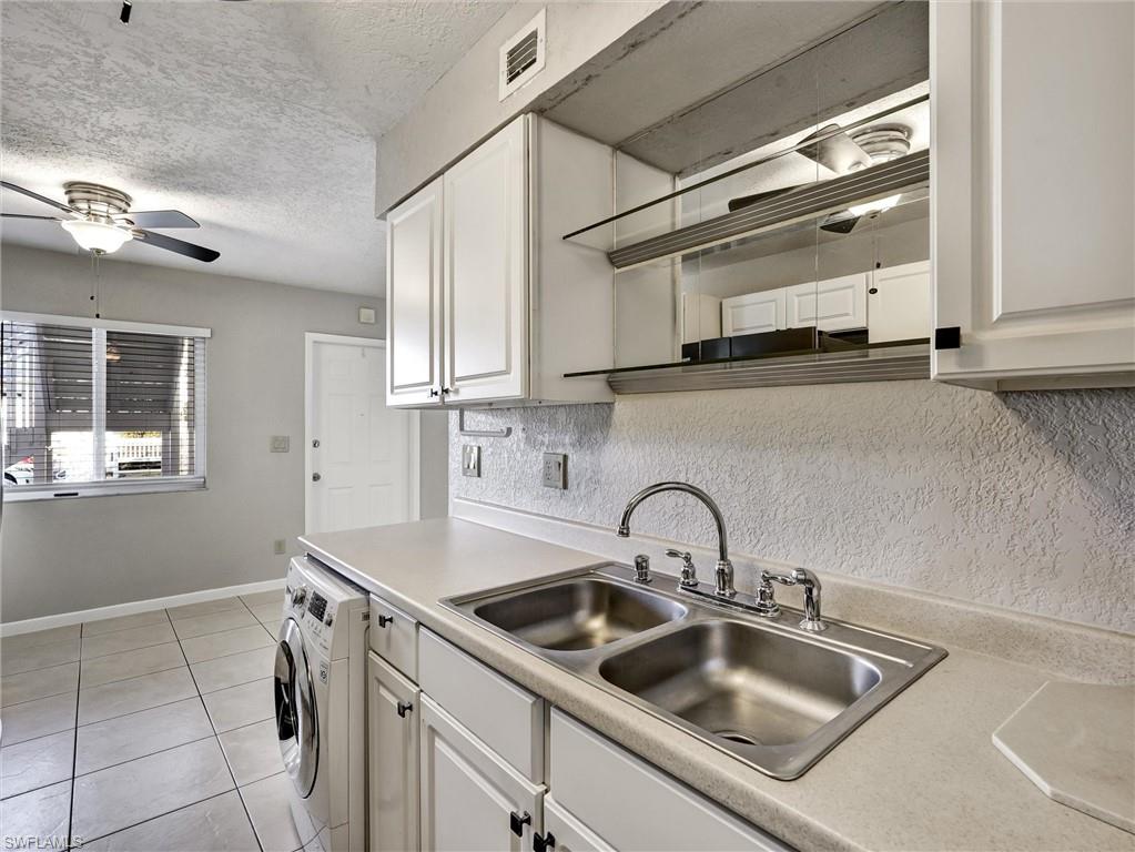 4621 Bayshore Drive, Unit Q1 Naples, FL 34112 - Photo 14 of 25 a kitchen with a sink and cabinets